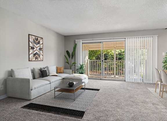 2-Bedroom Apartments in Raleigh, NC - Bridges at North Hills - A Living Room With Carpet Flooring, A Light Gray Sectional Sofa, A Coffee Table, And Sliding Glass Doors Leading To A Patio.