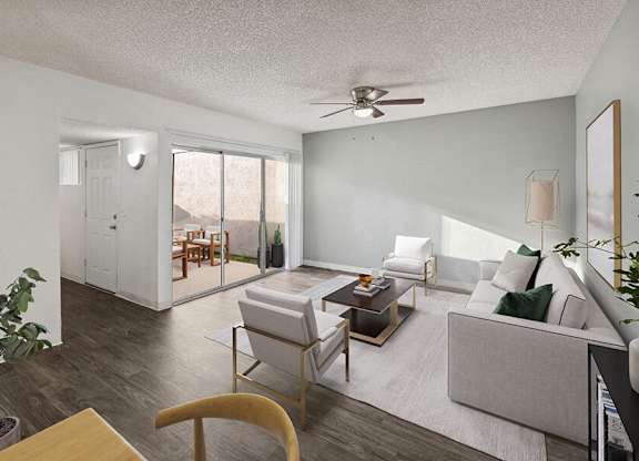 Three-Bedroom Affordable Apartments in East Tucson, AZ - Lakeside Casitas - A Living Room With Sofa, Armchairs, Coffee Table, Ceiling Fan, And Sliding Glass Doors Leading to Private Courtyard.