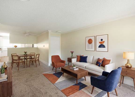 A living room with a white couch, a blue chair, and a wooden coffee table.