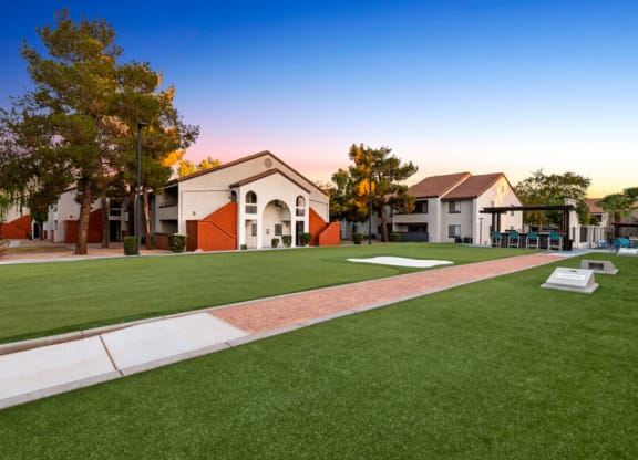 a green lawn in front of a building with a playground at Lore South Mountain, Phoenix, Arizona