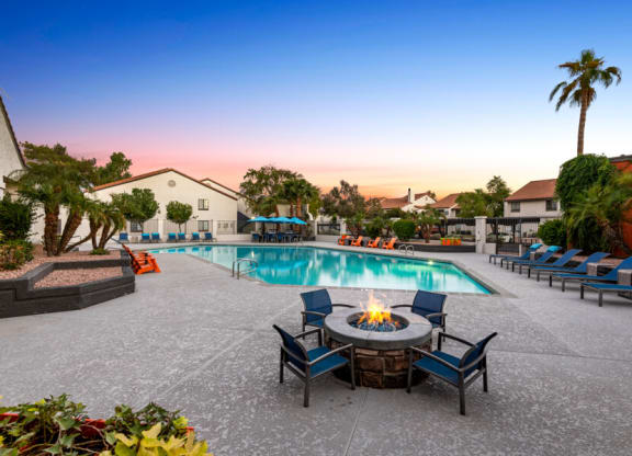 a swimming pool with a fire pit and chairs around it at Lore South Mountain, Phoenix