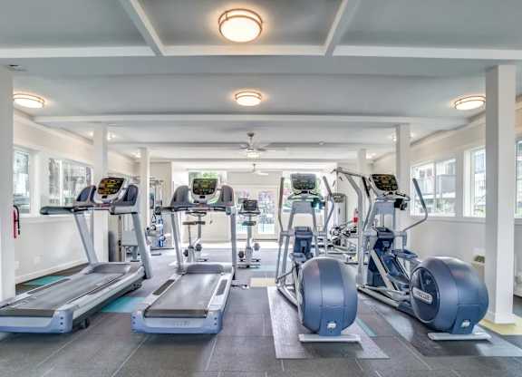 A gym with treadmills, elliptical machines, and other exercise equipment.