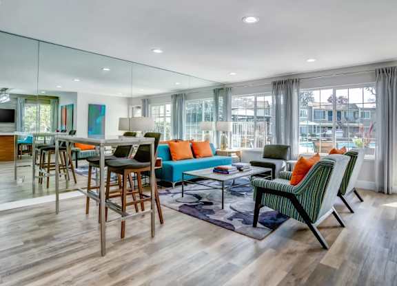 A modern living room with a glass wall and a wooden floor.