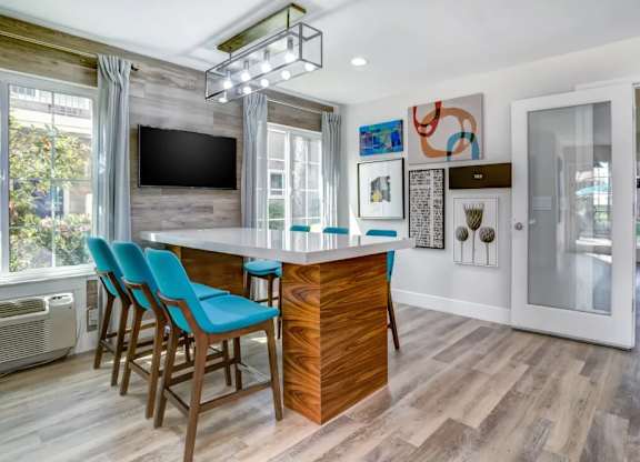 A modern kitchen with a bar area and a television.