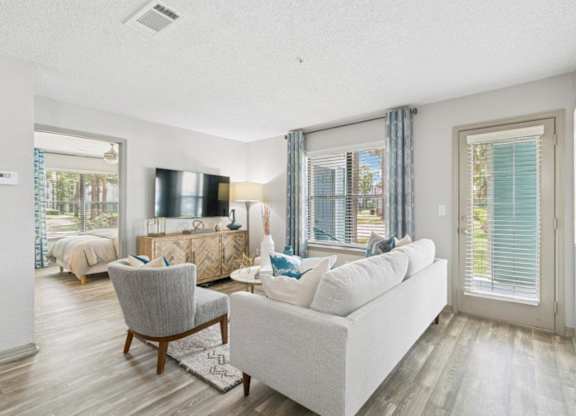 A living room with a grey couch, a chair, and a television.
