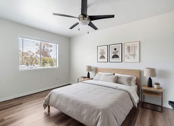 A bedroom with a large bed and a ceiling fan.