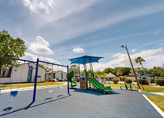 Community playground with slides and swings at Oasis at Bayside in Largo, FL.