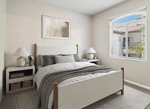 A bedroom with a large bed and two lamps.