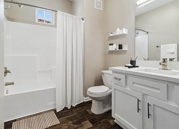 A white bathroom with a toilet, sink, and bathtub.