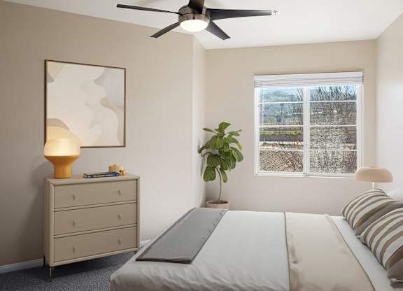 A bedroom with a bed, a dresser, a ceiling fan, and a window with a view of trees outside.