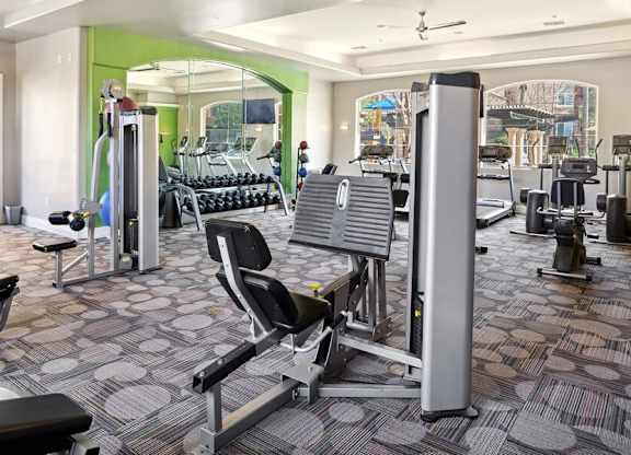 A gym with a variety of equipment including a weight machine and a bench press.