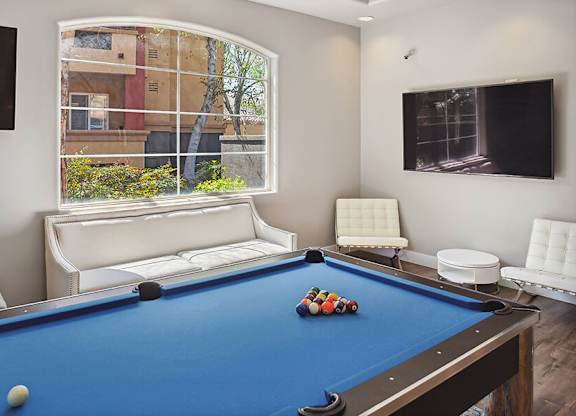 A pool table with a blue cloth and a white ball on it.