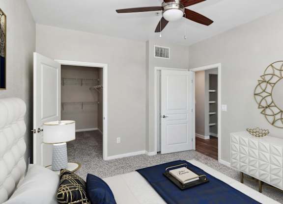 A living room with a white couch, a blue rug, and a ceiling fan.