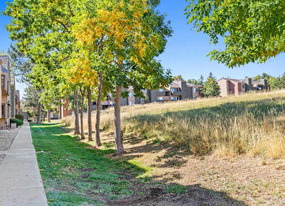 A row of houses with trees in front of them.