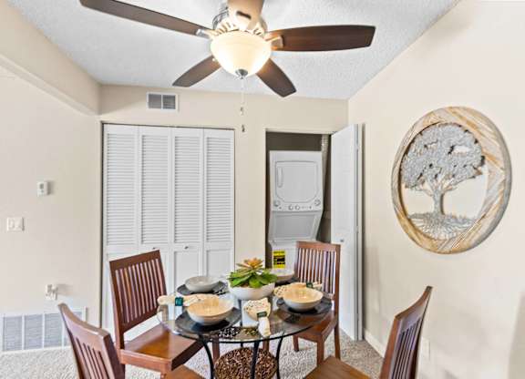 A dining room with a table set for four.