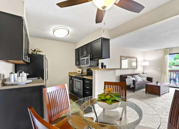A modern kitchen with a dining table set for two.