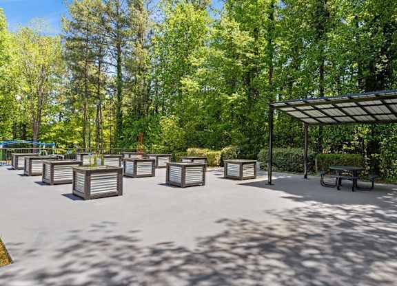 A park with a pavement, trees, and a shelter.