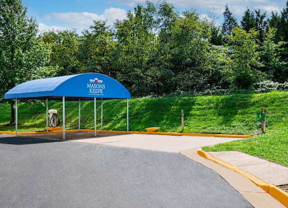 A blue canopy with a white sign that says "Masons Keefe" is in front of a grassy area.