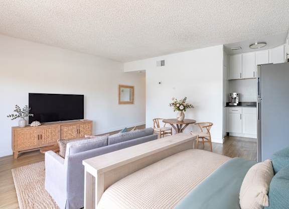 A living room with a grey couch and a wooden cabinet.