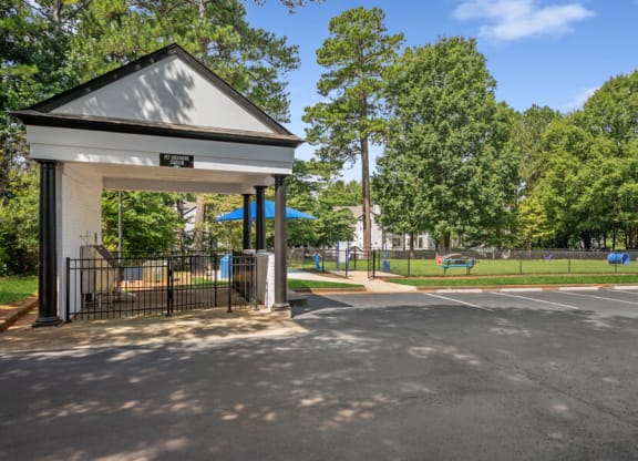 a bus stop with trees in the background and a parking lot in the foreground