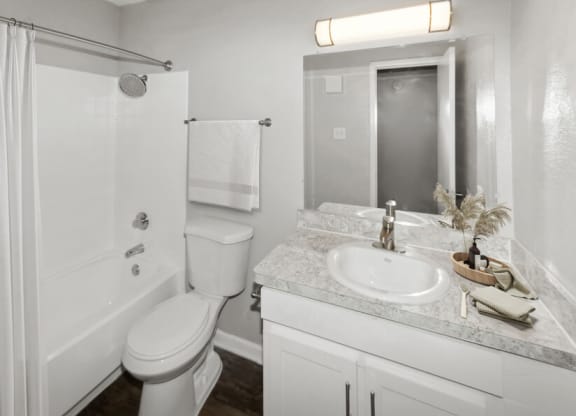 a white bathroom with a sink toilet and shower