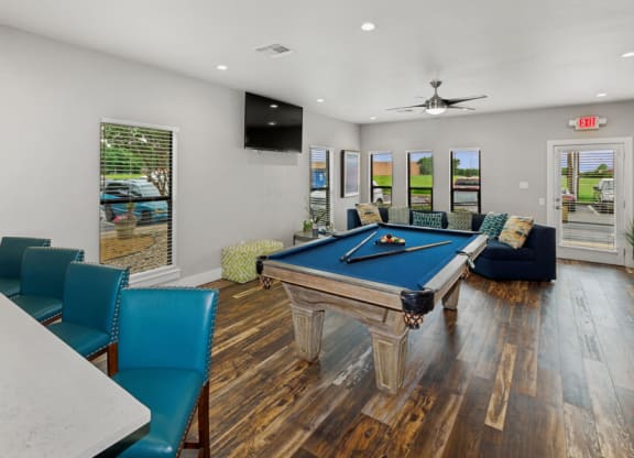 Community game room with a pool table and chairs