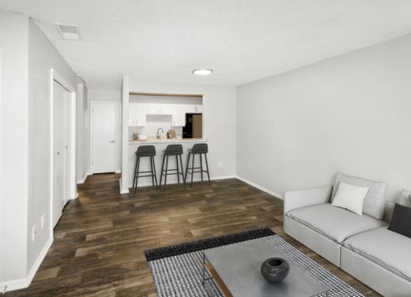 Model apartment living room with a couch and two bar stools