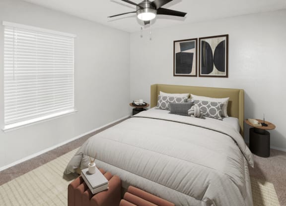 Model apartment bedroom with a bed and a ceiling fan
