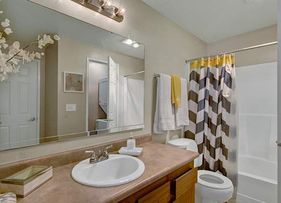 Model Bathroom with a Shower and Bathtub at Ridge & Shores Apartments located in Federal Way, WA.