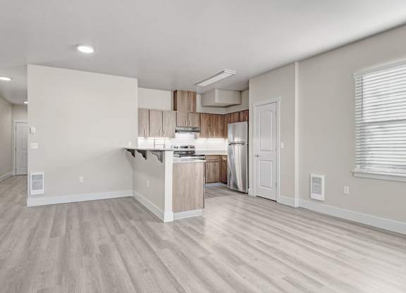 A spacious kitchen with a bar area and a dining table.