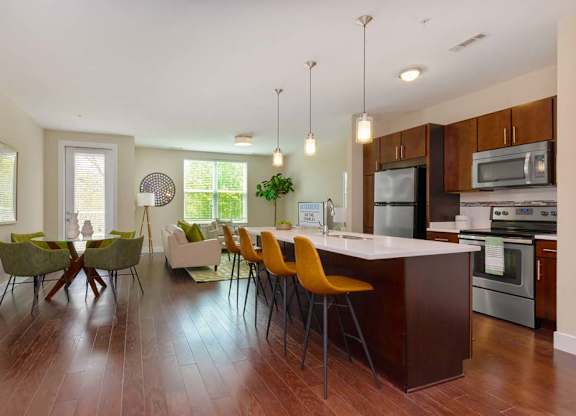 A kitchen with a long island and chairs.