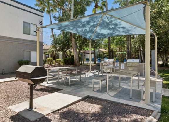 a patio with tables and chairs and a grill