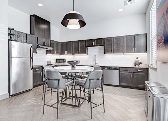 A modern kitchen with a table and chairs.