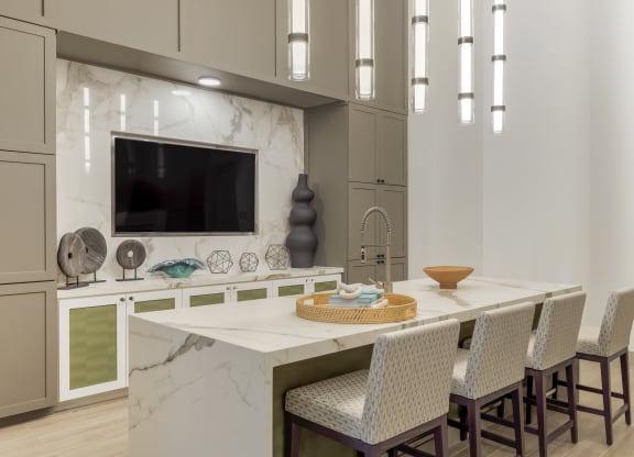a kitchen with a large center island with a breakfast bar and a flat screen tv