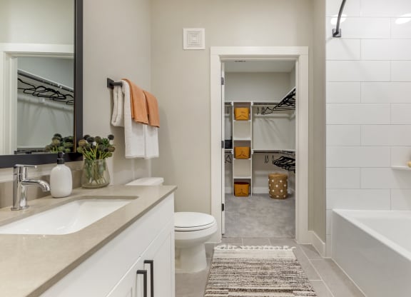 a bathroom with a tub and a toilet next to a sink