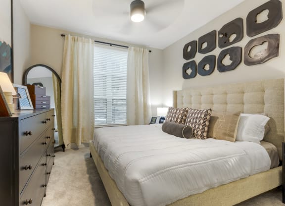 a bedroom with a large bed and a dresser with a mirror