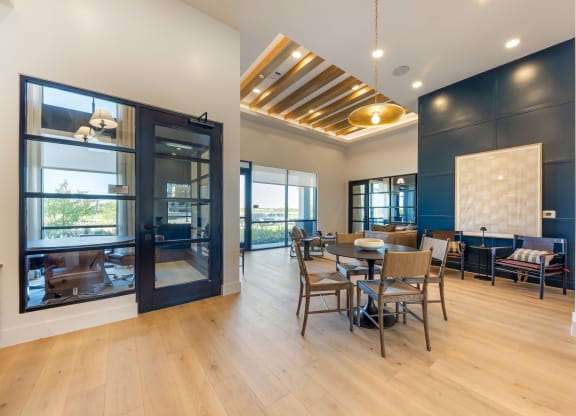 a dining room with a table and chairs and large windows