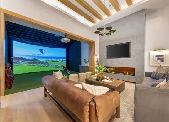 a living room with a couch and a tv and a view of the golf course