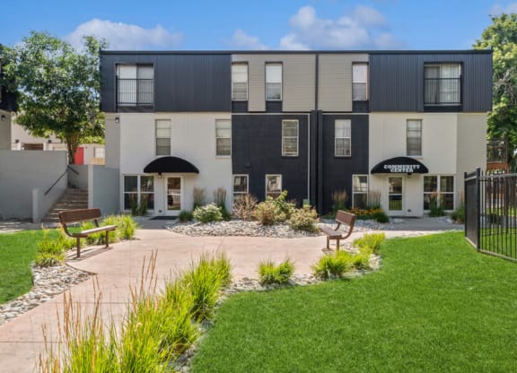 a courtyard with two benches and a bench in front of the apartments