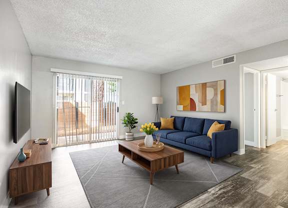 Model Living Room with Wood-Style Flooring at Bridges at Tropicana Apartments located in Las Vegas, Nevada.
