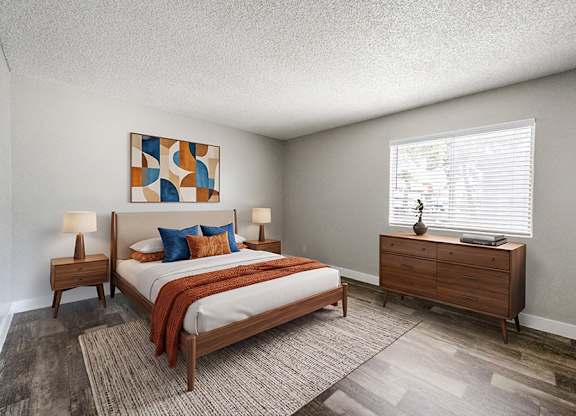 Model Bedroom with Wood-Style Flooring at Bridges at Tropicana Apartments located in Las Vegas, Nevada.