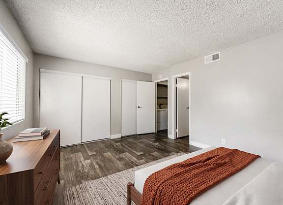 Model Bedroom with Wood-Style Flooring at Bridges at Tropicana Apartments located in Las Vegas, Nevada.