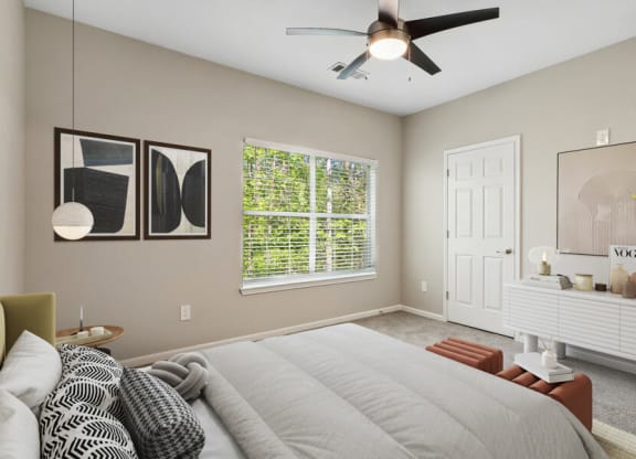 Model apartment bedroom with a large bed and a ceiling fan