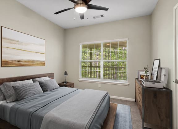 Model apartment bedroom with a bed and a ceiling fan