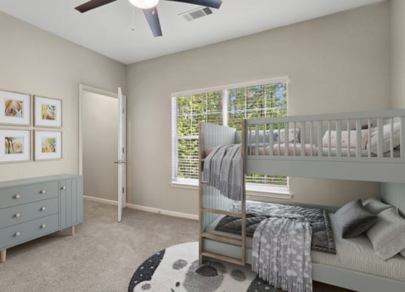 Model apartment bedroom with a bunk bed and a window