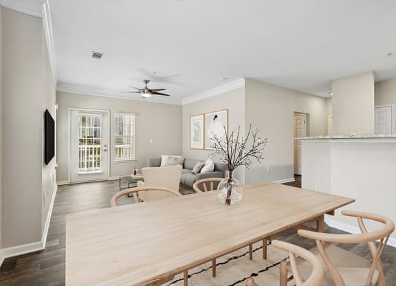 a living room and dining room with a wooden table