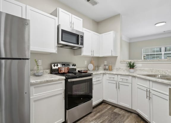 Model apartment kitchen with stainless steel appliances and white cabinets