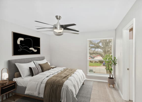 a bedroom with a bed and a ceiling fan