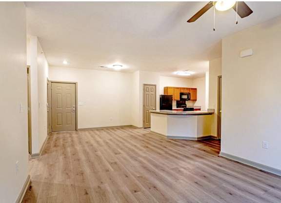 A room with a wooden floor and a ceiling fan at Arbours at Satsuma Apartments, Mobile, Alabama