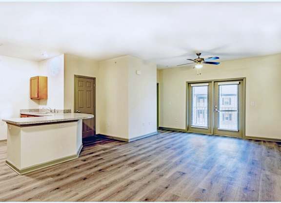 A room with a wooden floor and a white ceiling with a fan at Arbours at Satsuma Apartments, Mobile